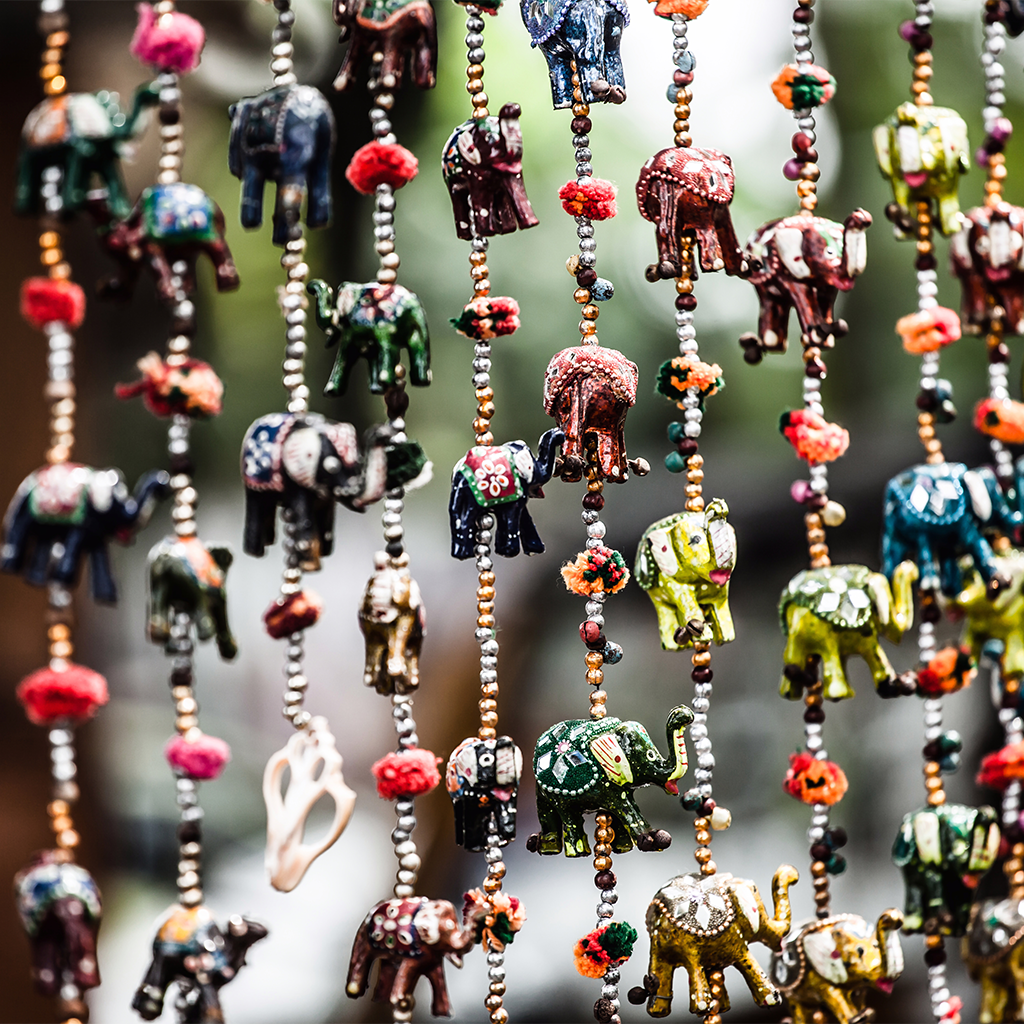 Strings of decorative elephant beads hanging from a string in a market in Kochi India