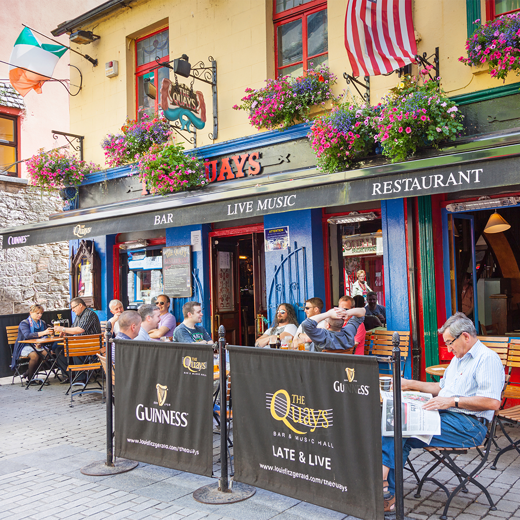 A group of people sitting outside of Quays restaurant in city centre Galway Ireland